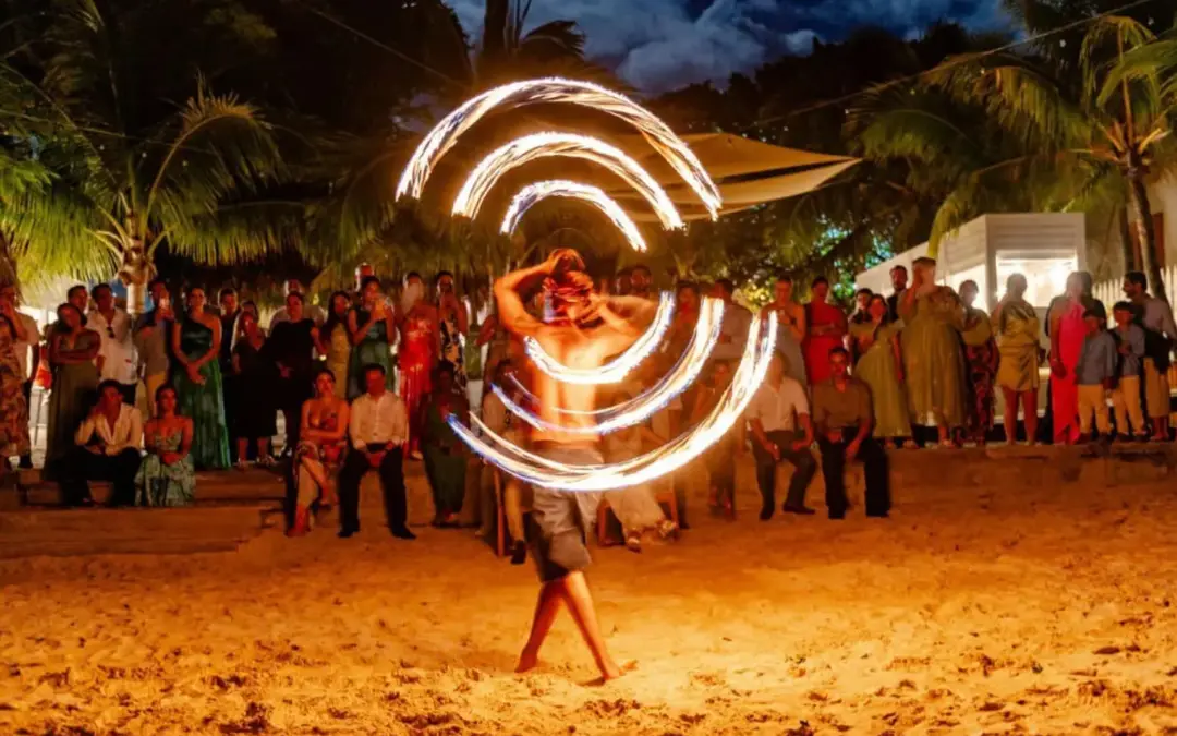 Fire dancer spinning flaming rings at a beach fire show in Roatan