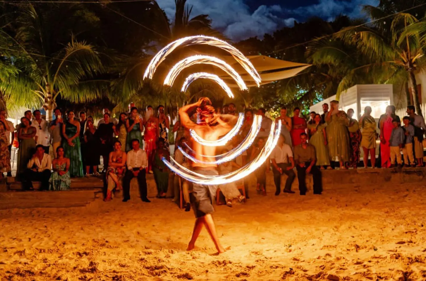 Roatan Guides & Tips 3 Fire dancer spinning flaming rings at a beach fire show in Roatan