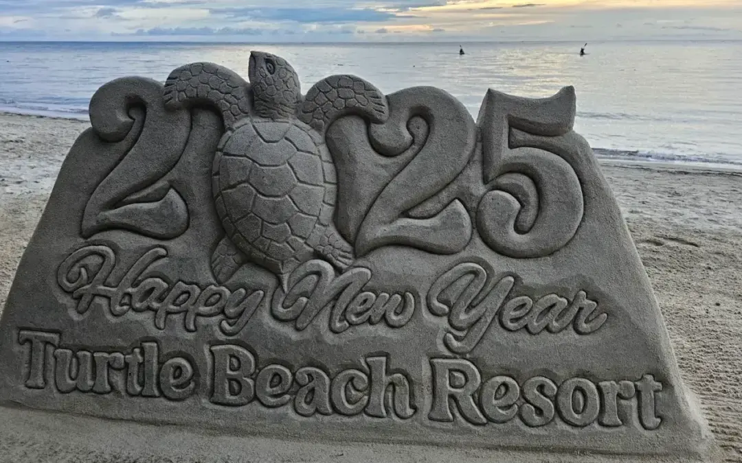 Happy New Year 2025 sand sculpture with a sea turtle at Turtle Beach, West End, Roatan